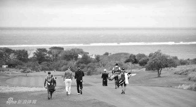 选手在果岭边复杂地势中谨慎选择球杆，面临艰难的攻果岭一击，身后是波涛起伏的太平洋