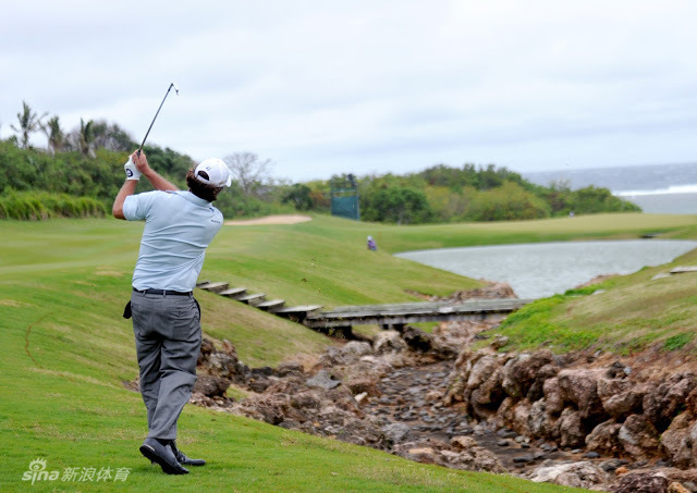 高尔夫名将马特·库查尔全神贯注地俯身观察果岭推杆线路，手中的推杆即将决定小白球在风中的最终命运