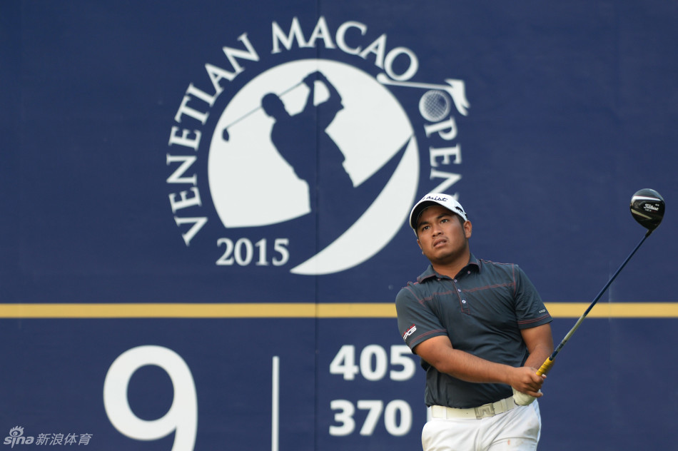 中国高尔夫名将梁文冲在澳门公开赛果岭上仔细研判推杆路线,表情沉稳专注。