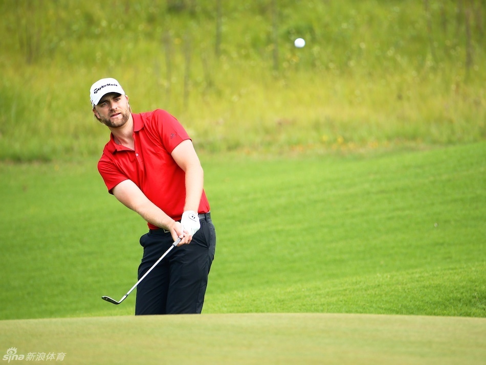 张新军站在发球台上审慎地观察球道,远处的沙坑和水障碍构成了他必须精准规划的挑战。