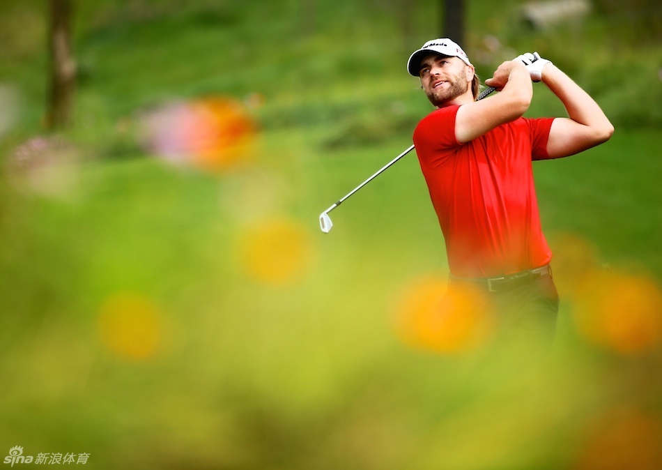 大卫·卢特鲁斯在果岭边进行切杆,他的姿势优雅而稳定,眼神中充满了对小球落点的预判与期待。