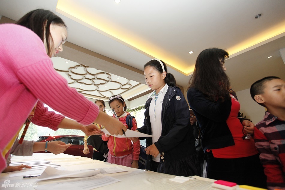 一群身着鲜艳球衣的孩子们整齐地排成两行,像等待检阅的小士兵,一张张红扑扑的脸蛋上写满了专注与期待,正准备开启他们的绿茵之旅。