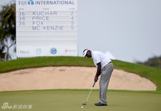 一位身穿红色上衣的志愿者撑着伞，在雨中露出灿烂笑容，她的热情如同斐济的阳光，温暖了紧张的赛场