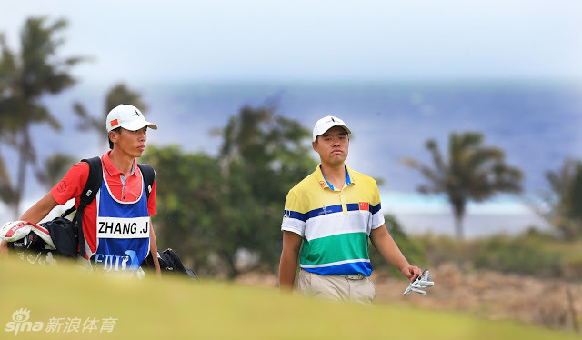 张进在雨中暂停击球，利用小憩时刻擦拭球杆并思考下一杆策略，沉着冷静