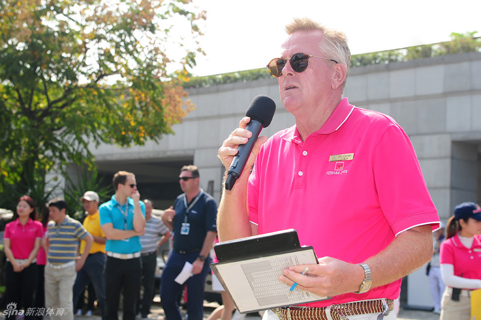 年轻的中国高尔夫球星关天朗在果岭上俯身仔细观察球路,准备进行关键一推,神情专注而沉着。