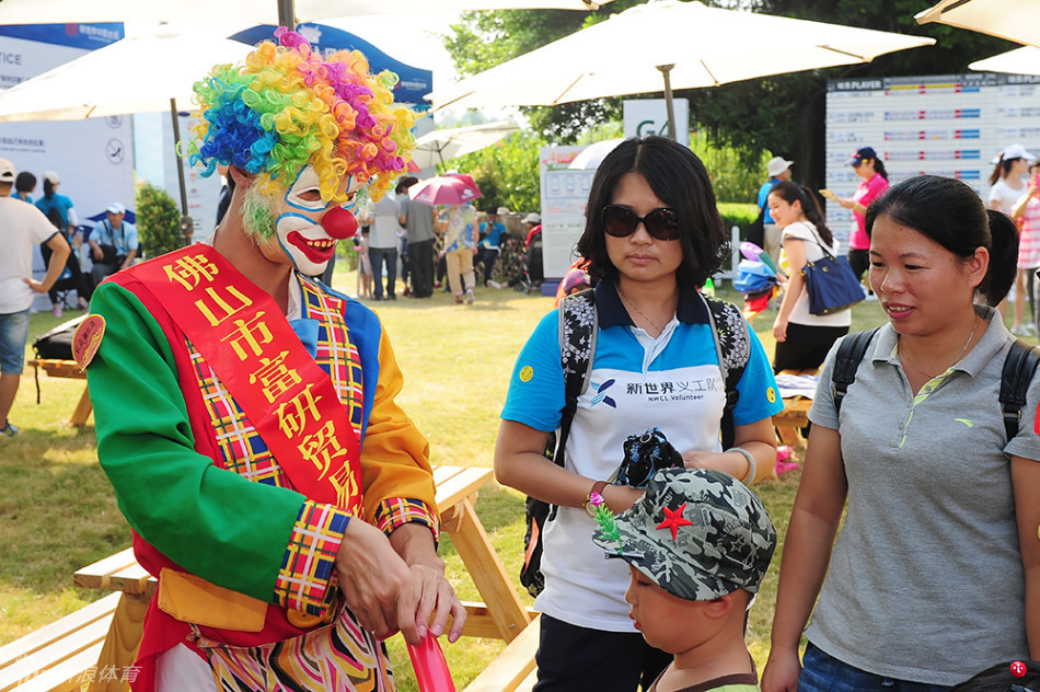 身穿缤纷服装的小丑正专注地为小朋友捏制一个长颈鹿造型的气球,孩子眼中满是期待的光芒