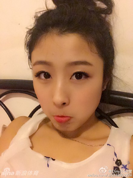 黄思莹身穿深色牛仔短裙搭配简约白T恤，倚靠在栏杆上，回眸一笑，展现出生活中邻家女孩的清纯气息