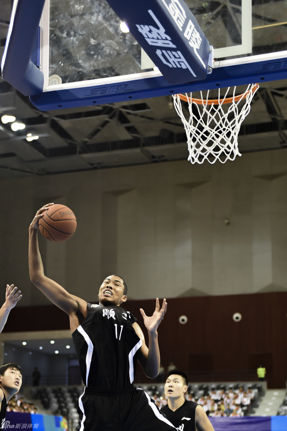 丘天在青运村的宿舍里，与队友们围坐在电视机前，神情专注地观看比赛录像，画面定格在他们认真研究的侧影上。