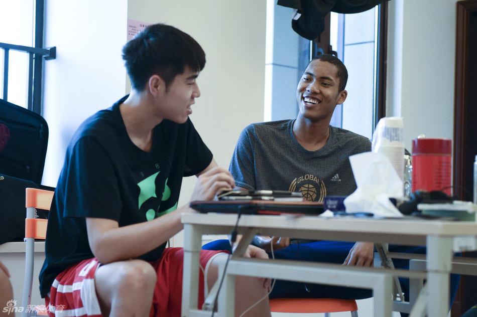 比赛暂停期间，丘天弯下腰，侧耳倾听主教练张云松的战术布置，眼神中充满对指令的信任与思索。