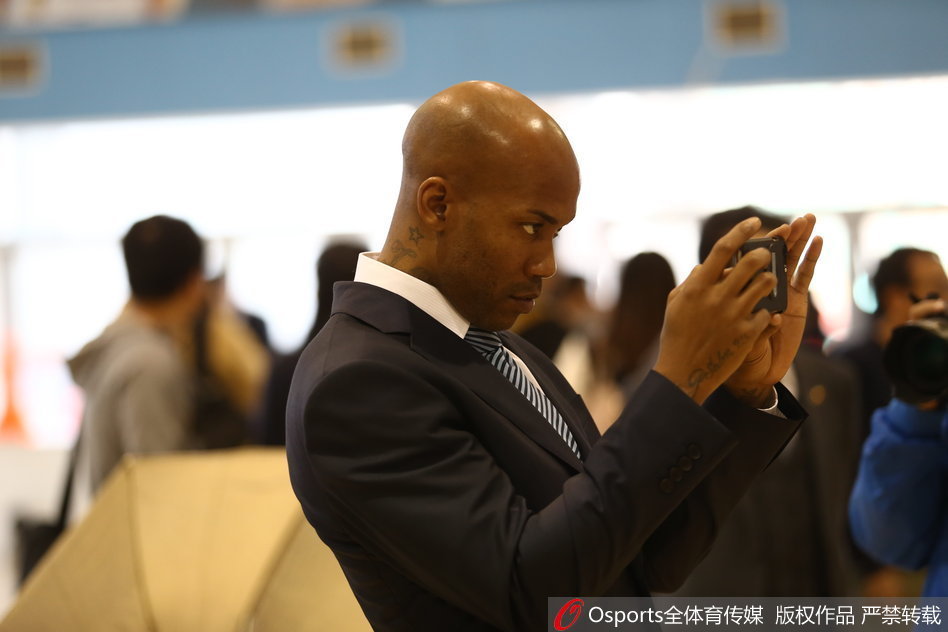 马布里单膝跪地，双手将篮球递给身前的方硕，方硕俯身接球，两人神情专注，仿佛在进行一场神圣的火炬交接仪式。