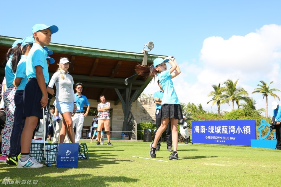 一位小球员在教练的指导下成功击球，白色的小球在空中划出弧线，他的脸上瞬间绽放出惊喜与成就感。