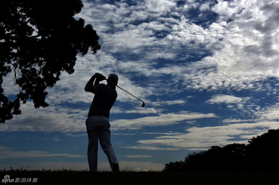 美国选手罗相昱在果岭上仔细阅读转折复杂的推杆线路，他的眼神紧盯着草纹与坡度。