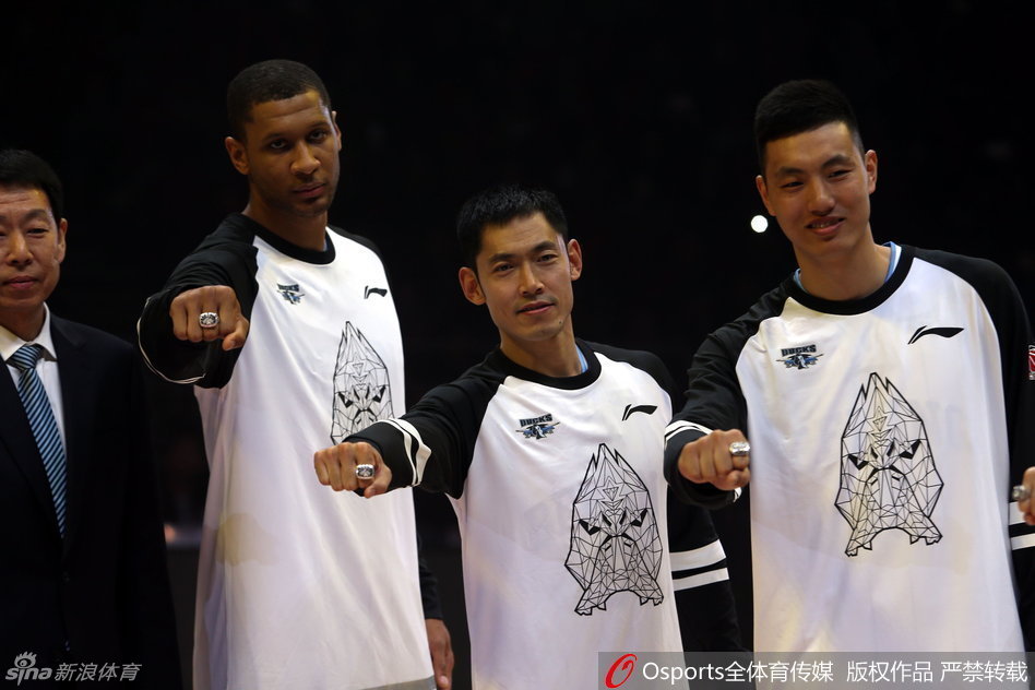 北京队核心球员孙悦在颁奖台上，手持总冠军戒指，目光坚定，身旁的朱彦西方硕等队友也沉浸在获得这份至高荣誉的喜悦之中。