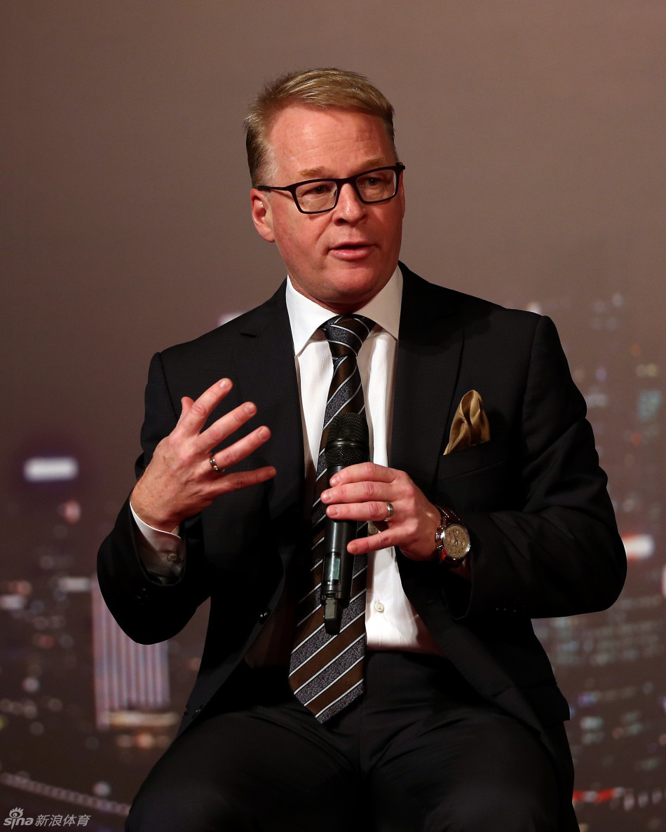 美巡赛专员蒂姆·芬臣正在台上发表演讲，阐述美巡赛的全球视野与发展战略，背景屏幕播放着精美的赛事视觉材料