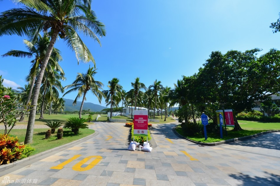 黄昏时分,球场笼罩在温暖的金色光线中,长长的影子投射在球道上,呈现出一幅宁静、优美而略带梦幻色彩的球场风光画卷。