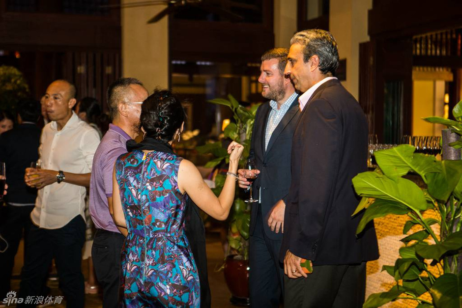 晚宴现场交流侧影:镜头捕捉到晚宴一角,两位嘉宾正侧身深入交谈,背景是光影朦胧的宴会现场,氛围典雅而私密