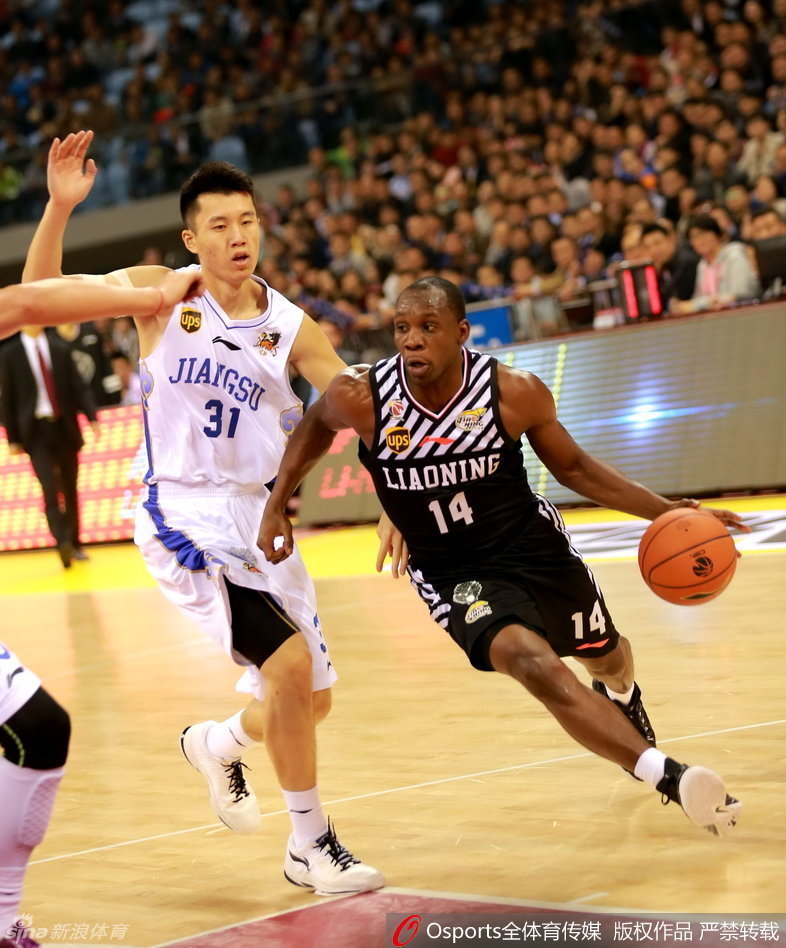 奥登身着便装坐在场边观战，眼神深邃而复杂，他手戴厚重的护具，仿佛在诉说着那些被伤病侵蚀的岁月。