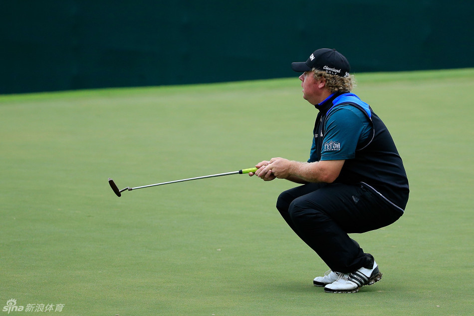 错失良机后的落寞：果岭边，一位球员低头看着自己刚推出的球偏离线路，双手叉腰，背影与神情中流露出无法掩饰的失望与自我怀疑。