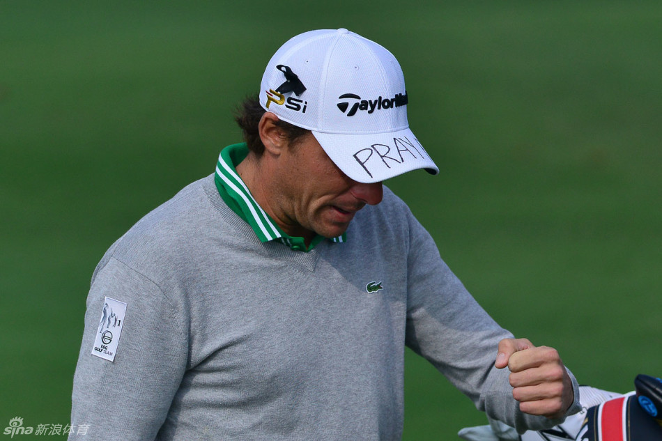 球员们集体低头默哀的庄严场景，赛场一片寂静，只有旗帜在风中飘扬，展现了对逝去生命最崇高的致敬。