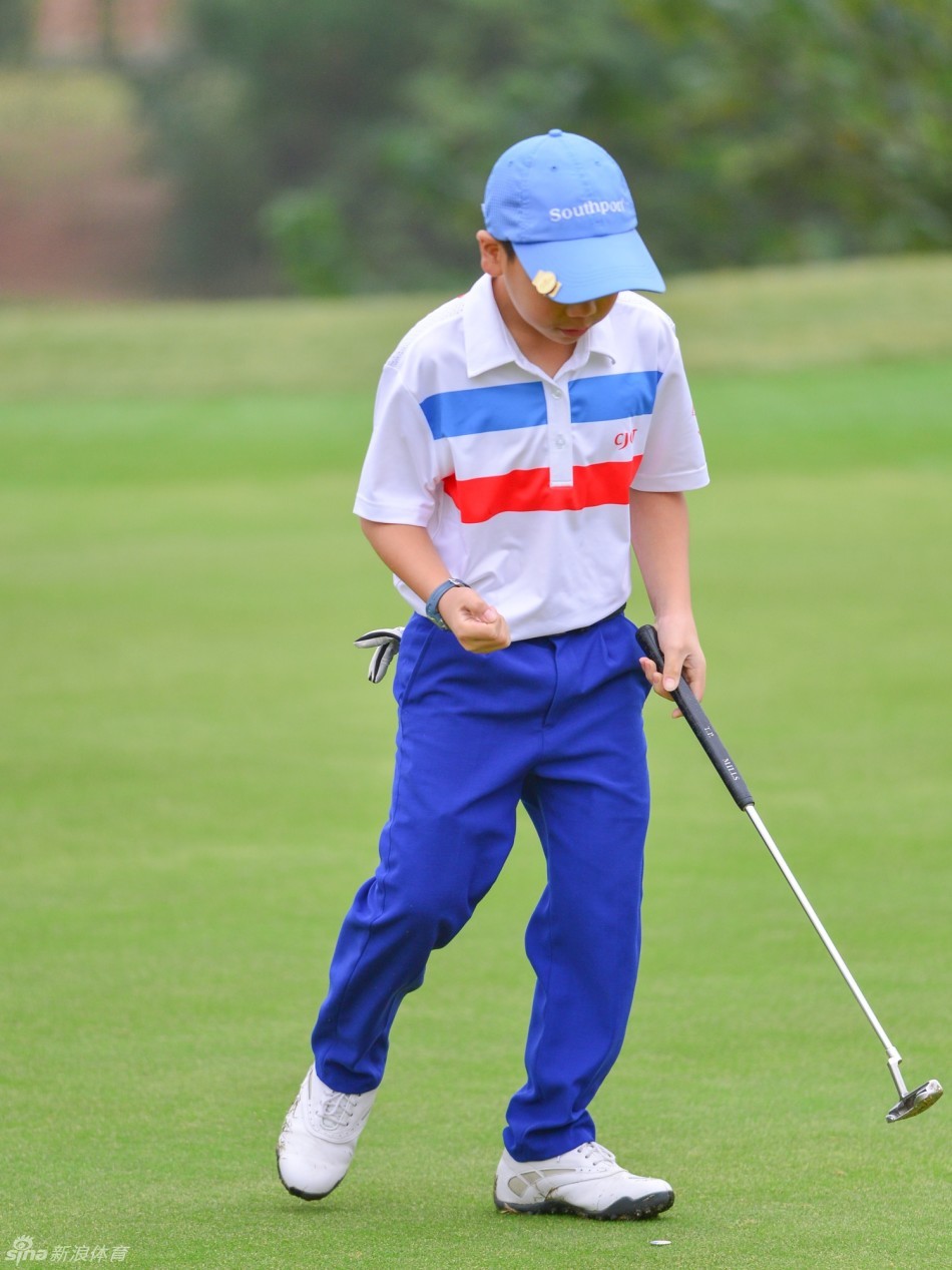 比赛中的小球员正仔细观察果岭，阅读复杂的坡度与草纹走向