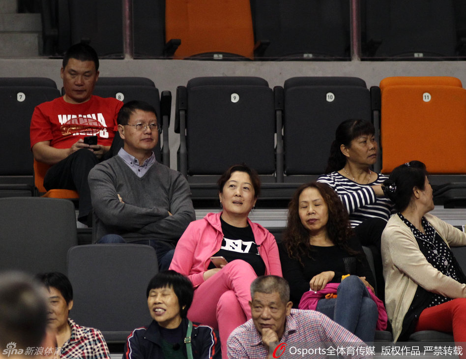 易建联用球衣遮住面部，难掩激动之情，身后是呼啸而过的赛场和热情的球迷。