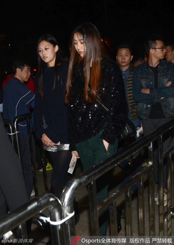 陈露双手自然垂放，身姿挺拔地站立于球场通道，背景是喧闹的看台，她却自成一道静谧风景。