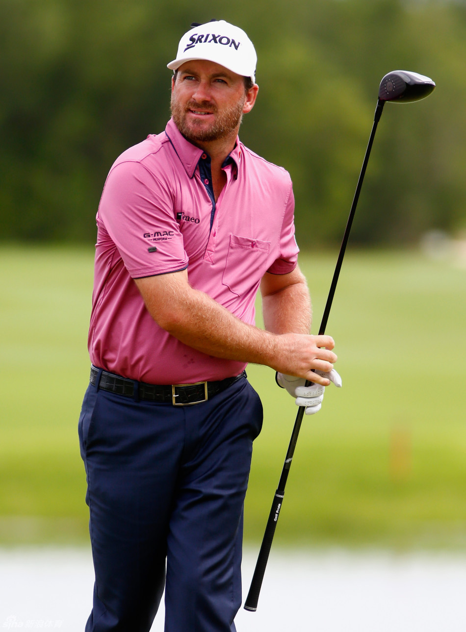 斯科特-布朗表情凝重立于球道，手握球杆陷入沉思，身后是雾气氤氲的广阔湖面