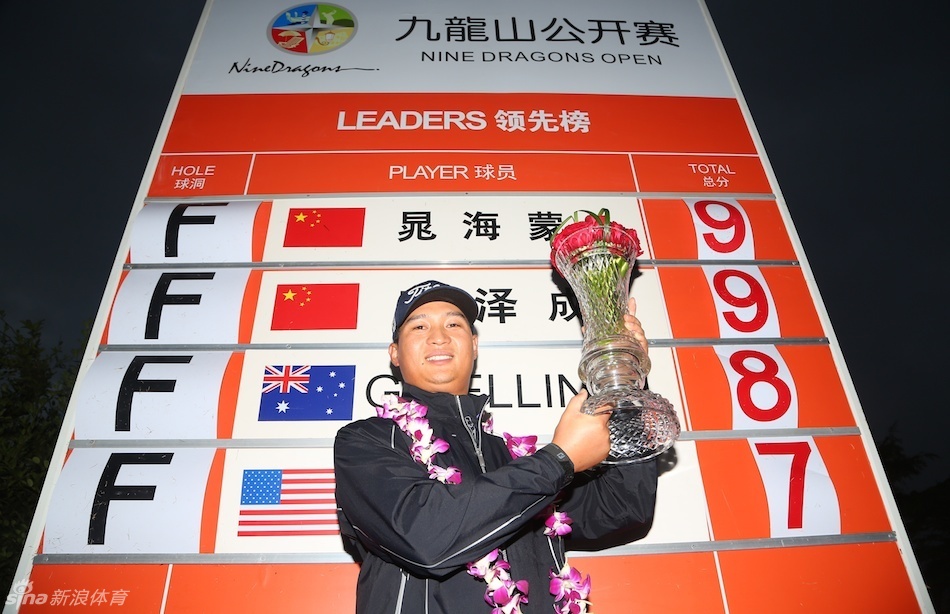 窦泽成在山脚下开阔的球道上准备击球，背景是起伏的山峦与草坪，画面宁静而充满力量感