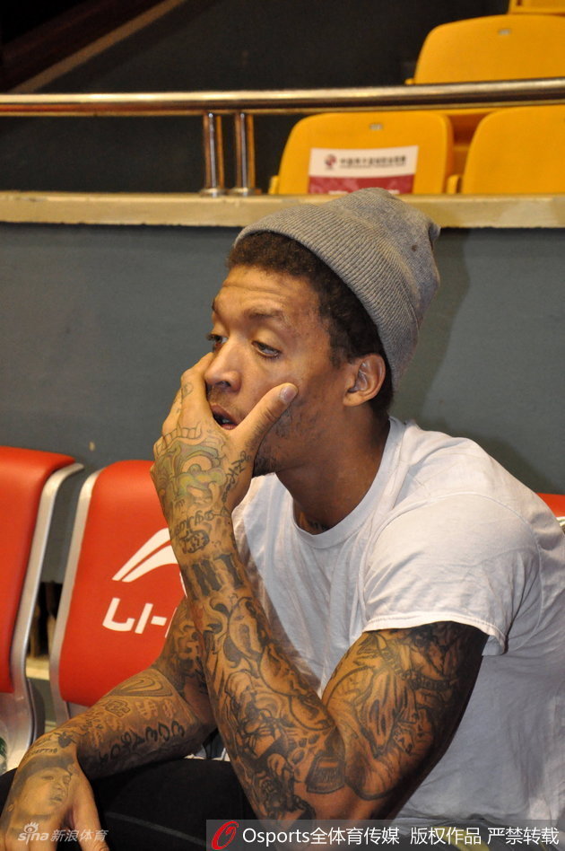 比斯利戴着一顶黑色毛线帽，对着镜头自信地整理帽檐，眼神中带着一丝戏谑，仿佛在问大家自己这造型够不够帅气。