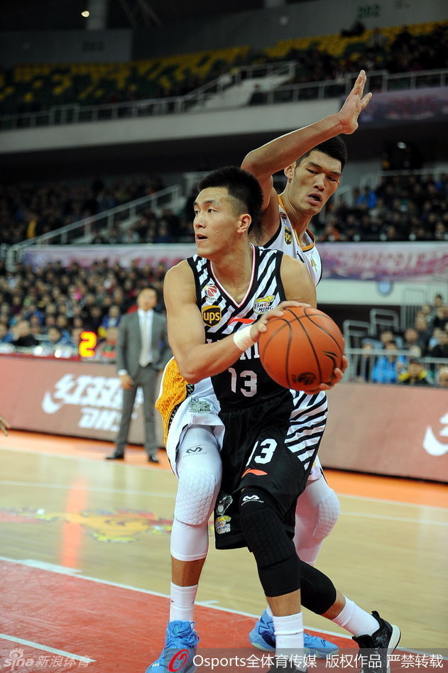 赵继伟受伤倒地后，表情痛苦地捂着自己的腿部，身边的队友和对手都纷纷举手示意，场边担架已准备好，现场气氛凝重。