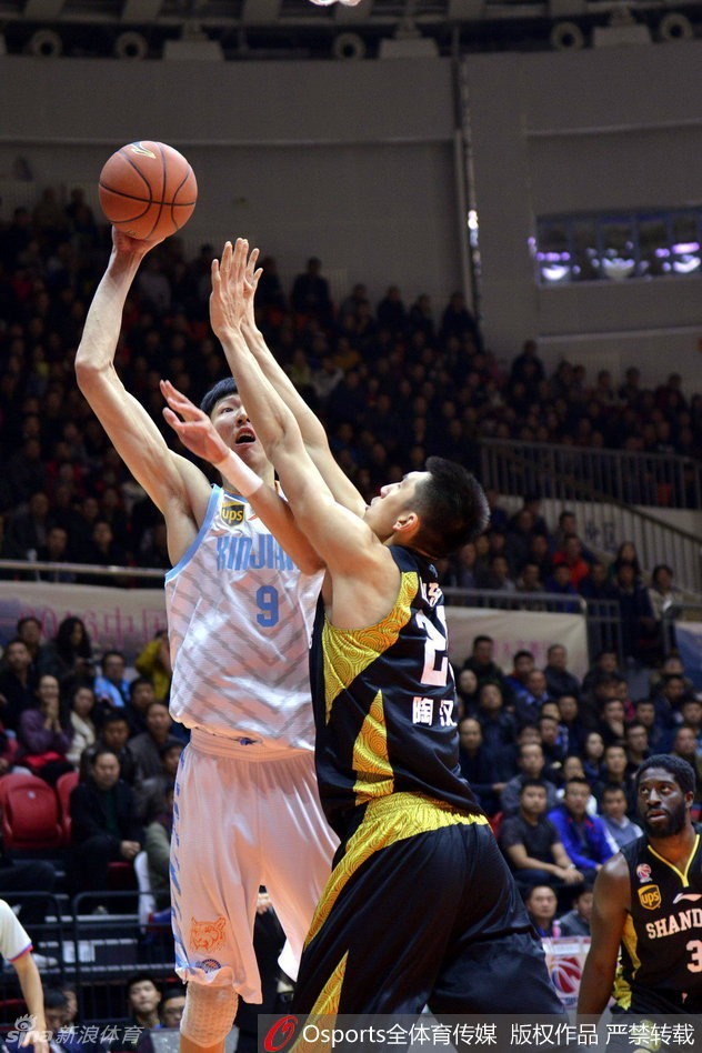 俞长栋在山东队防守球员的长臂干扰下，依然保持着完美的投篮姿势，篮球沿着指尖划出一道优美的弧线飞向篮筐。