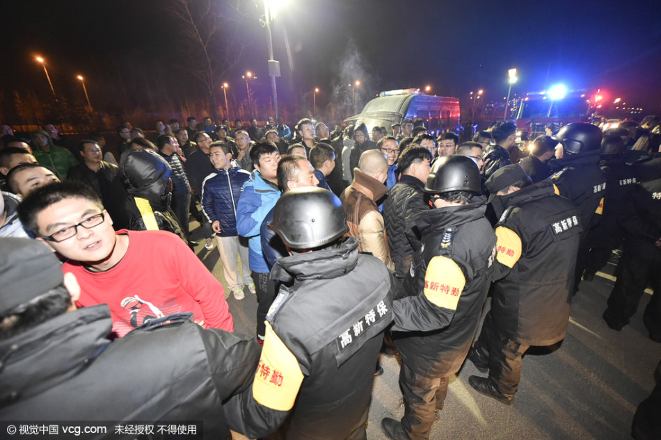 多名安保人员形成扇面包夹之势，用身体组成一道密不透风的移动屏障，紧紧拦在情绪高涨的球迷前方，手臂高高抬起，仿佛在无声地告诫：请止步于此，让激情留在看台。