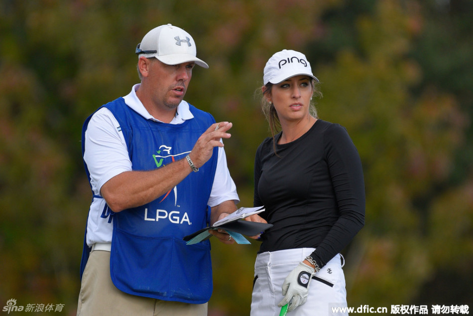 冯思敏与球童父亲并肩走在球道上，低头专注商讨策略，亲情的支持是她最坚实的后盾