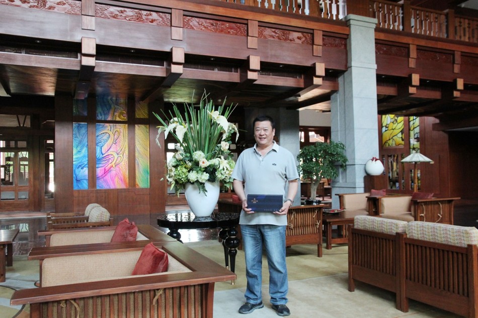 两位嘉宾手持华丽礼盒，在主题背板前愉快合影，记录下这难忘的瞬间