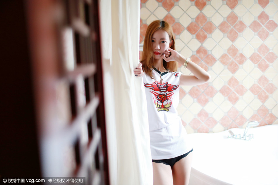 清纯球迷杨柳在酒吧中双手握拳抵在脸颊旁，做出可爱的加油姿势，眉眼间既有为球队揪心的楚楚动人之感，又充满了必胜的坚定信念