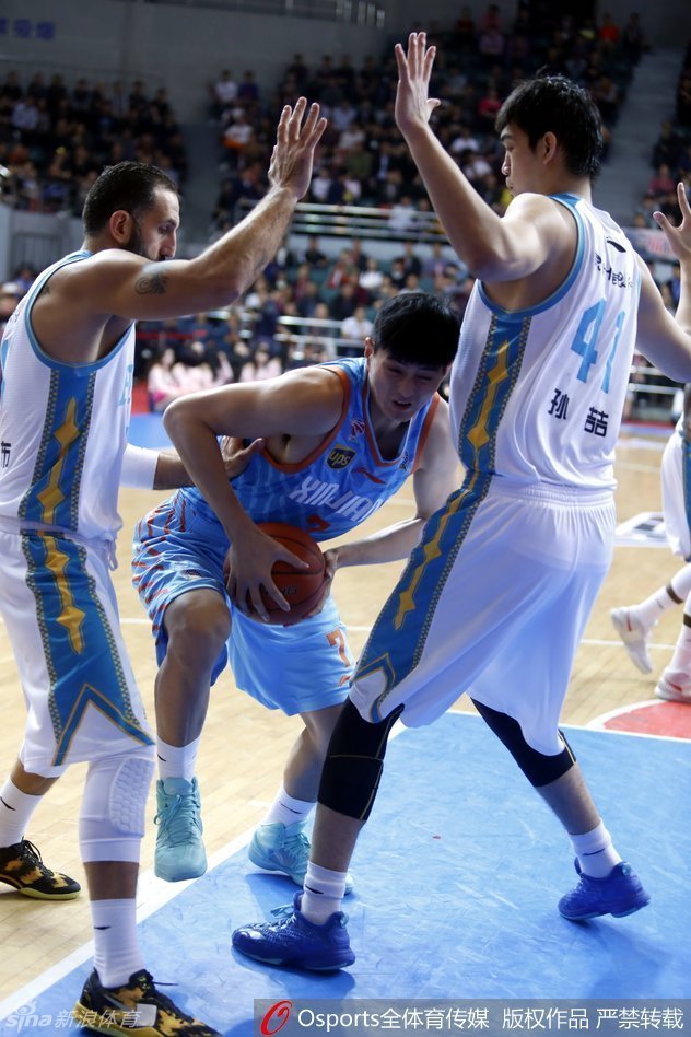 福建队外援拜克斯努力伸出双手试图接应队友，面对新疆队的严密防线，他的表情显得凝重而焦急，汗水布满脸庞。