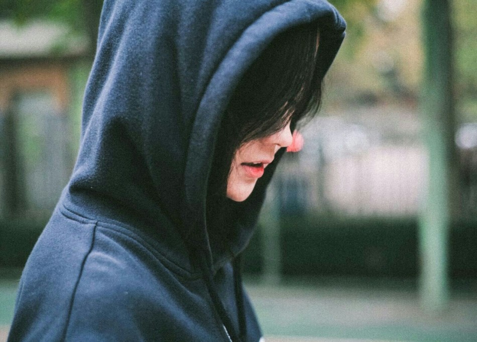 篮球女孩双手抱球望向远方，眼神清澈而坚定，身后的篮球场显得格外空旷宁静