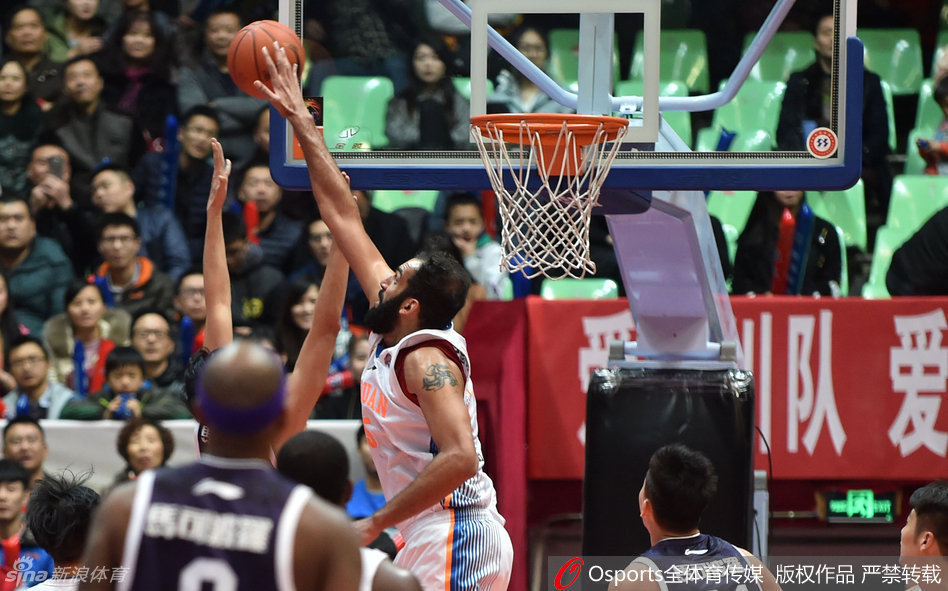 王哲林穿着便装坐在场边，眼神焦急地望着场内，不能上场的遗憾和对队友的关切，全都写在了他那紧锁的眉头上。