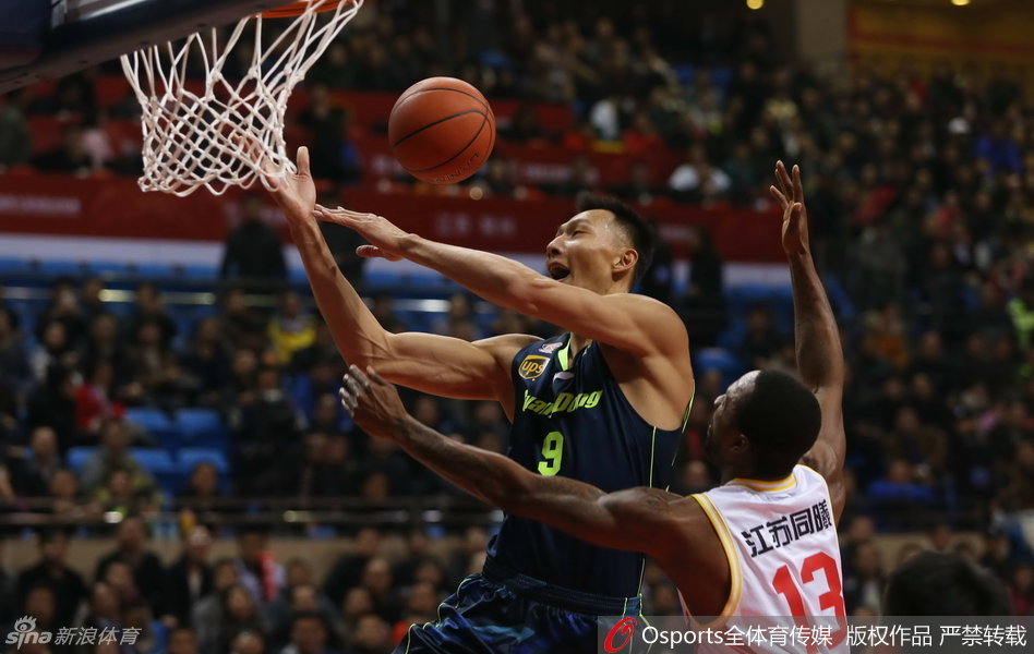 朱芳雨持球强行切入，他顶开防守者，眼神坚毅地注视着篮筐，展现出老将的勇猛。