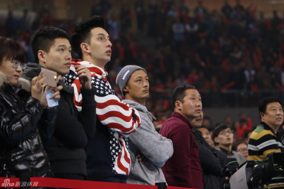 终场哨响，北京队险胜。余文乐与麦克隋在座位上露出满意的笑容，余文乐一边鼓掌一边看向好友，似乎在说这是一场属于篮球的胜利，两人身后的背景是正在退场的欢庆球迷。