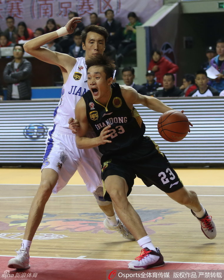 丁彦雨航持球从底线强行切入，眼神坚定，突破防守球员的封堵直杀篮下