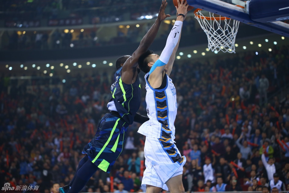 易建联在多名北京队球员的包夹防守下，依然艰难地起身上篮，表情坚毅，肌肉线条分明，展现出他作为球队核心极强的杀伤力与不屈的斗志。