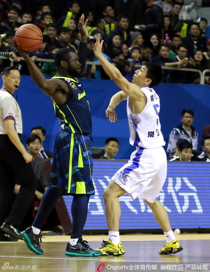 易建联高高跃起，在空中用单手将球揽入怀中，完成一次关键的篮板球争抢，眼神中充满对胜利的渴望。