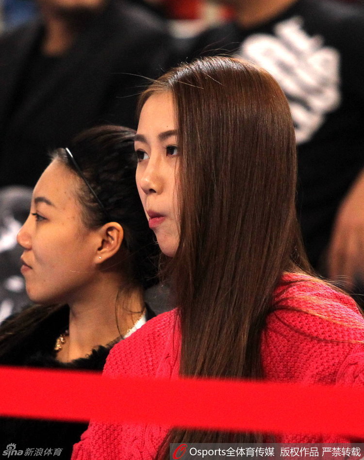 陈露全神贯注地盯着赛场，眼神随着丈夫孙悦的跑动而移动，右手轻轻托着下巴，优雅中透露出对比赛局势的丝丝紧张与期待