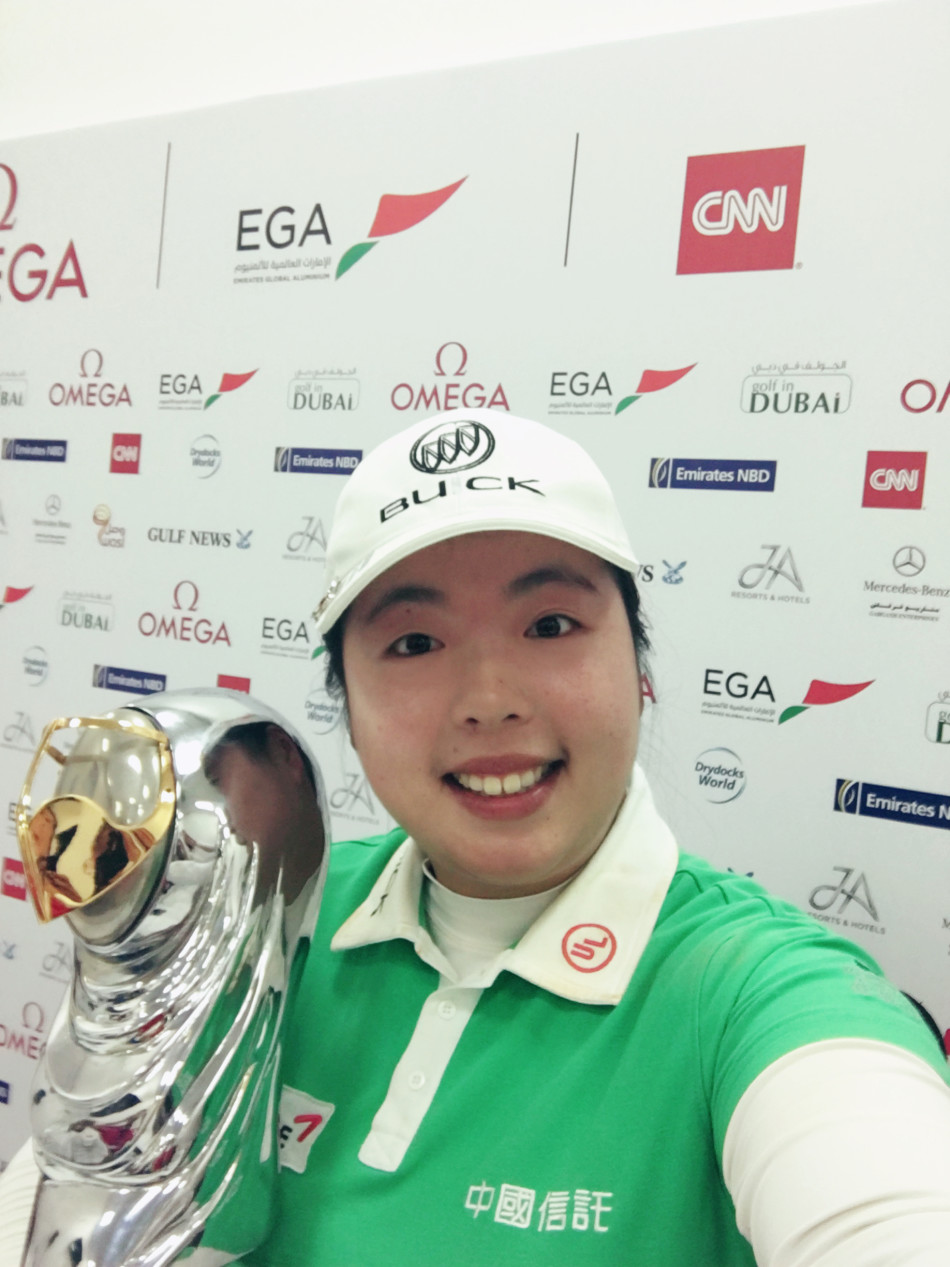 冯珊珊在迪拜酋长高尔夫俱乐部果岭上优雅推杆，神情专注而坚定，身后是迪拜标志性的城市天际线。