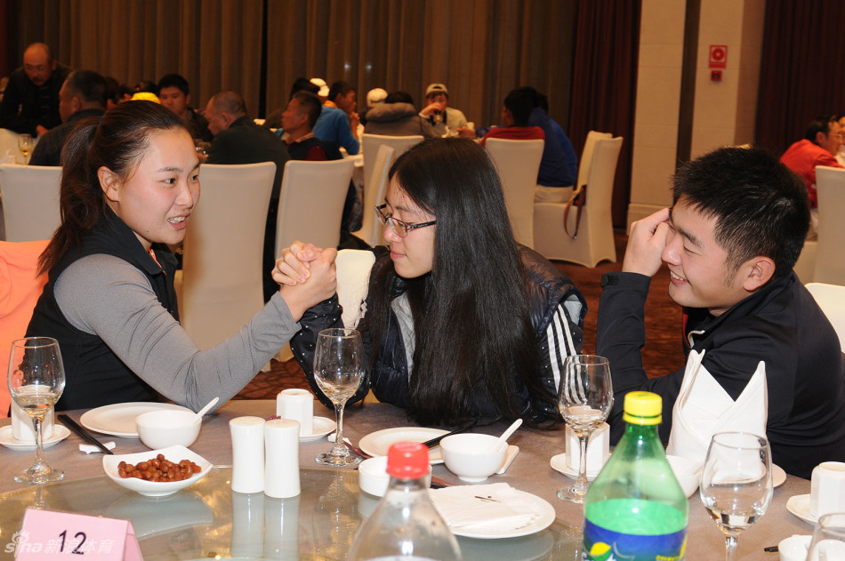 嘉宾与球员们在晚宴间隙参与轻松有趣的互动小游戏,画面中人们开怀大笑,气氛活跃,尽显赛事的欢乐与融合。