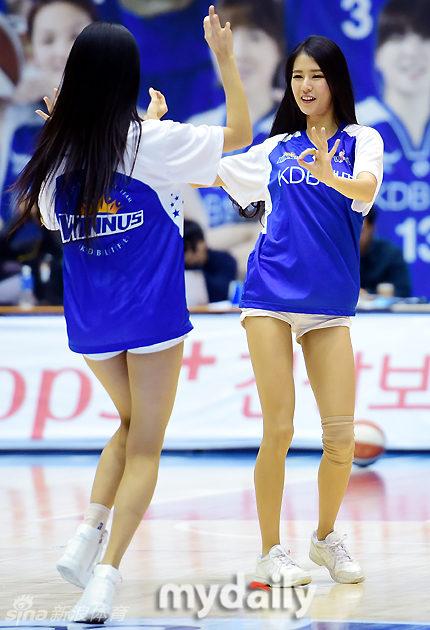 篮球宝贝们扎着清爽的马尾，身穿亮白色热裤，在球场中央高高跃起，修长的美腿在空中划出整齐划一的动人曲线。