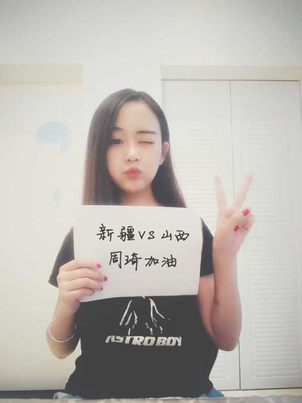 一位戴着眼镜的文静女球迷，在喧嚣的球馆中显得格外专注，她默默支持着场上的球员，或许心中正在预告着接下来的精彩赛况。