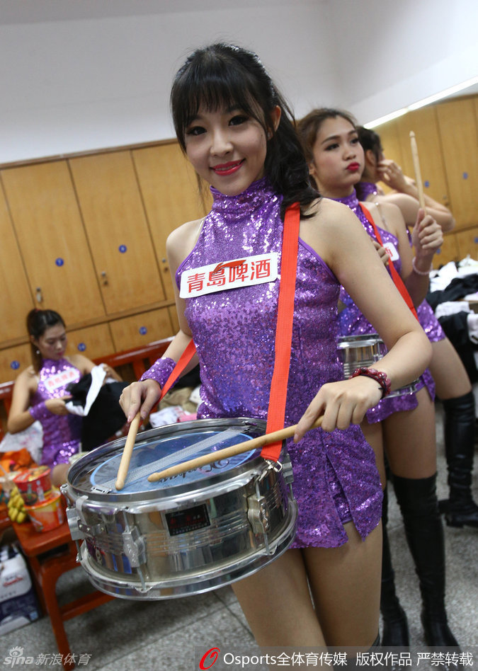 舞台中央，这位拿着鼓槌的宝贝化身‘打鼓小公主’，每一次有力的敲击都伴随着身体的律动，红色的流苏随着动作飞扬，仿佛在用最原始的音乐节奏点燃全场球迷的热情。