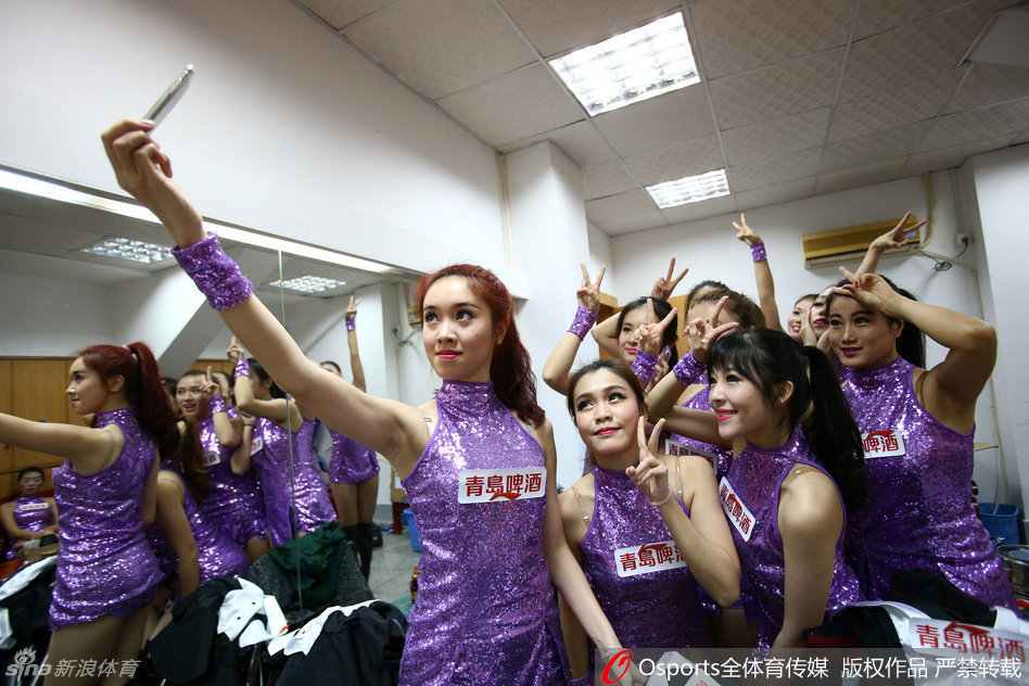 镜头定格在一位‘劈叉美女’的高光时刻，她在一字马动作中展现出惊人的柔韧度，双手轻轻触地，微卷的长发垂落，仿佛一只在球场中央优雅休憩的黑天鹅。